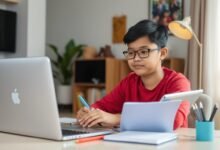Seorang mahasiswa sedang belajar online efektif dengan laptop dan buku catatan